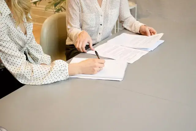 dos personas firmando documento